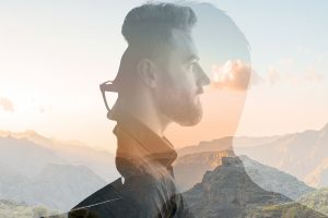 Triple exposure portrait of a man combined with beautiful mountain landscape at sunset