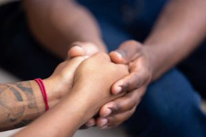 Black man friend holding hands of african woman, american family couple give psychological support